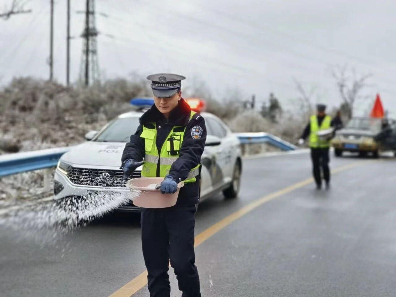 圖1民警在轄區(qū)結(jié)冰路段開展撒鹽除冰防凍工作。.jpg