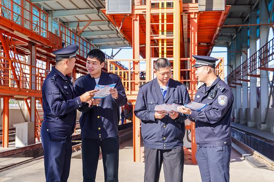 刑警支隊民警向企業(yè)職工發(fā)放宣傳資料并“一對一”講解電詐常識。謝仁古力·托呼提 攝